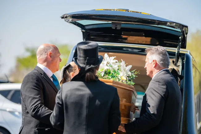 Coffin being loaded into a hearse